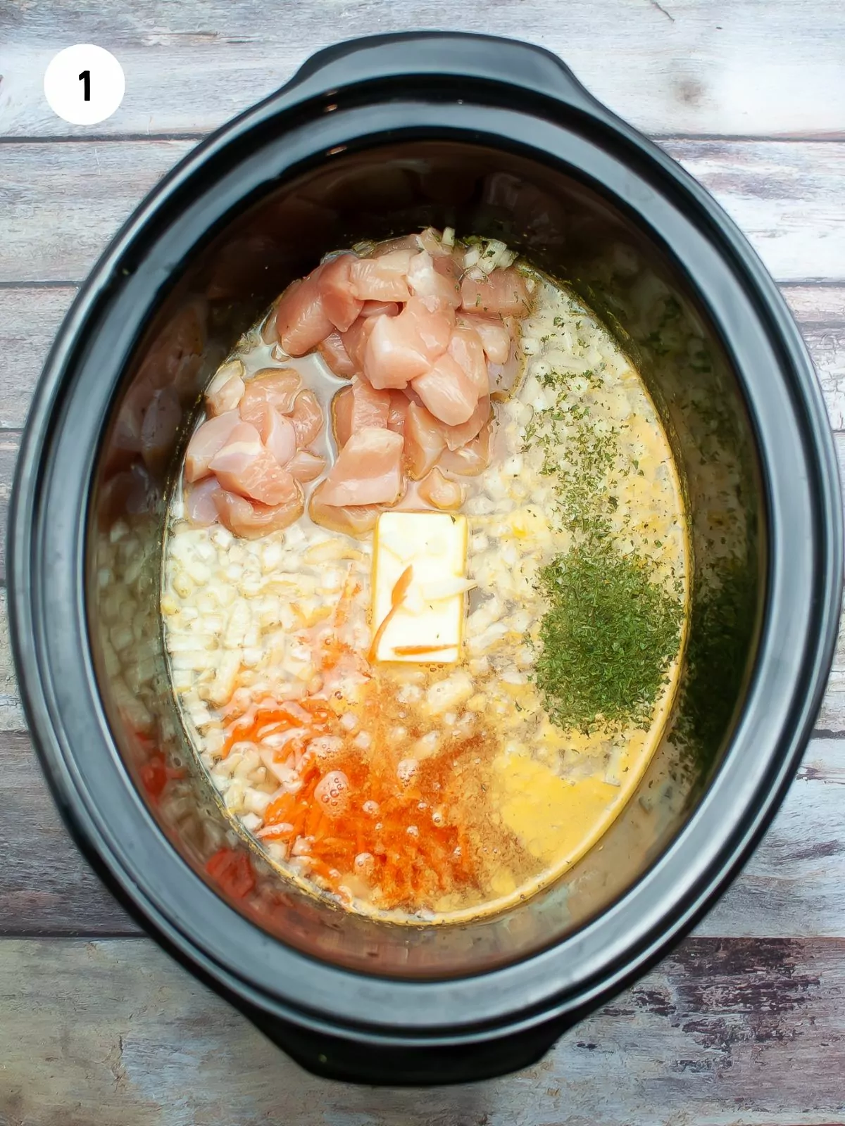 butter, onion, garlic, parsley, carrots, and chicken in the slow cooker