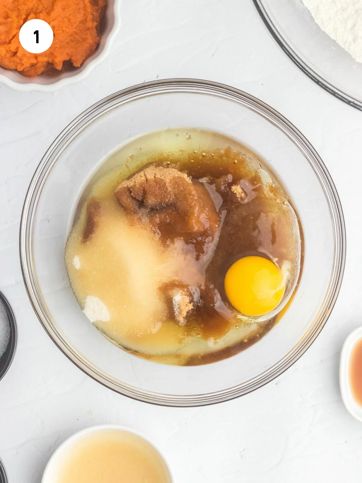 white sugar, brown sugar, oil, and eggs in a clear mixing bowl