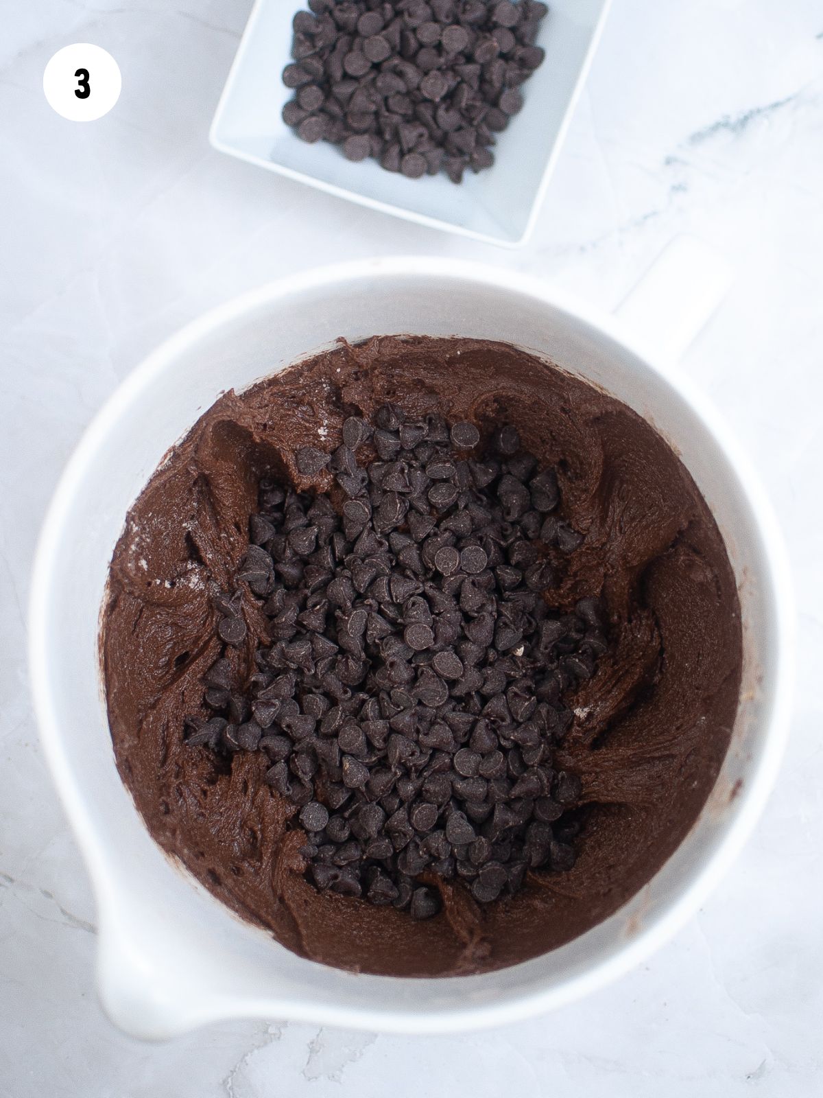 Chocolate muffin batter with chocolate chips about to be mixed in