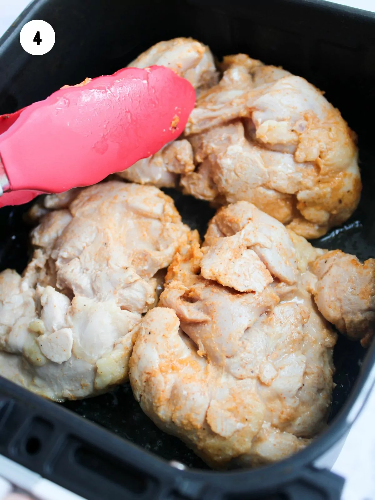 chicken thighs added to the air fryer basket