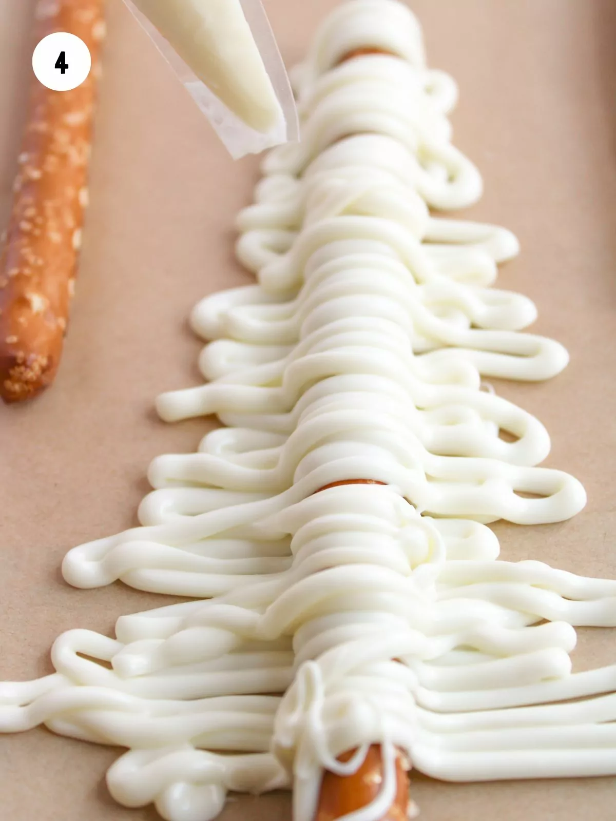 white chocolate piped in a tree shape over the pretzel rod