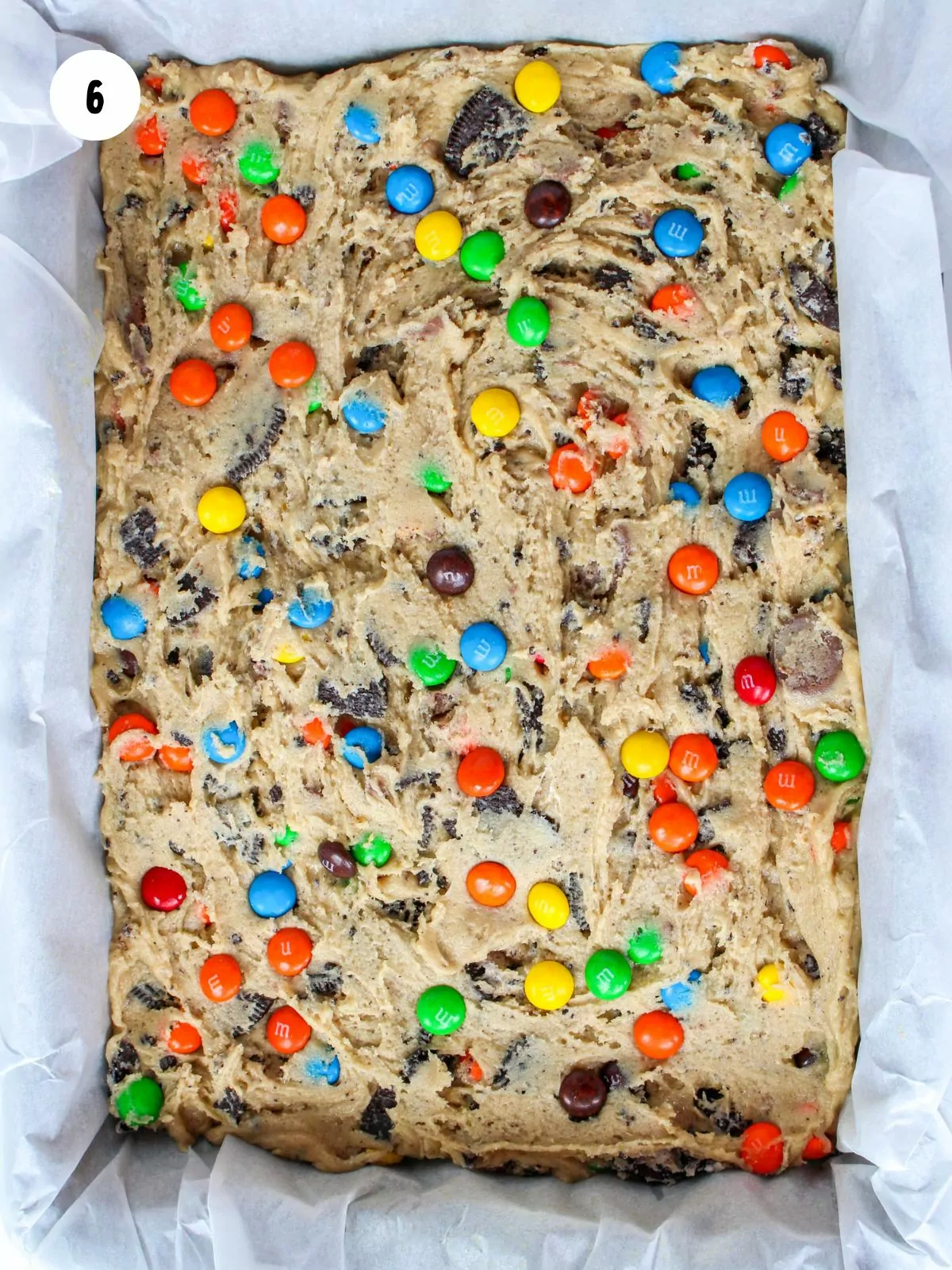 loaded cookie dough in parchment lined baking pan