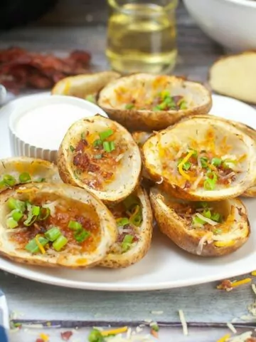 plate of potato skins with cheese, bacon, and green onions