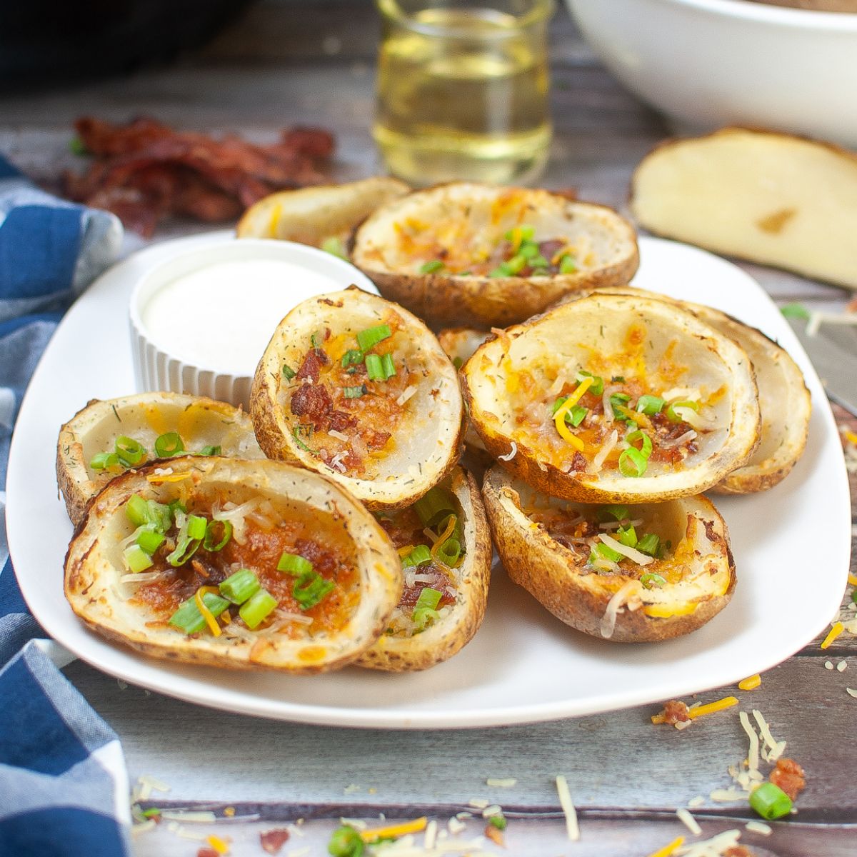 plate of potato skins with cheese, bacon, and green onions