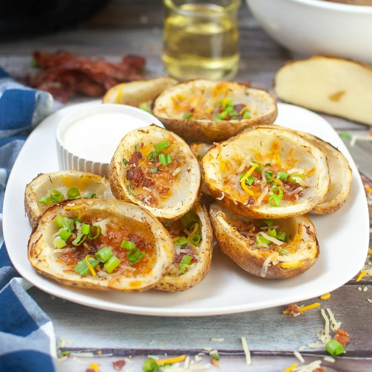 plate of potato skins with cheese, bacon, and green onions