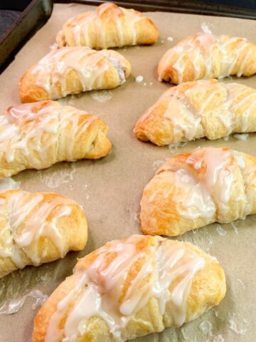 tray of crescent rolls with powdered sugar glaze.