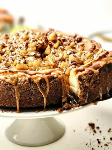 closeup of cheesecake on white cake stand.