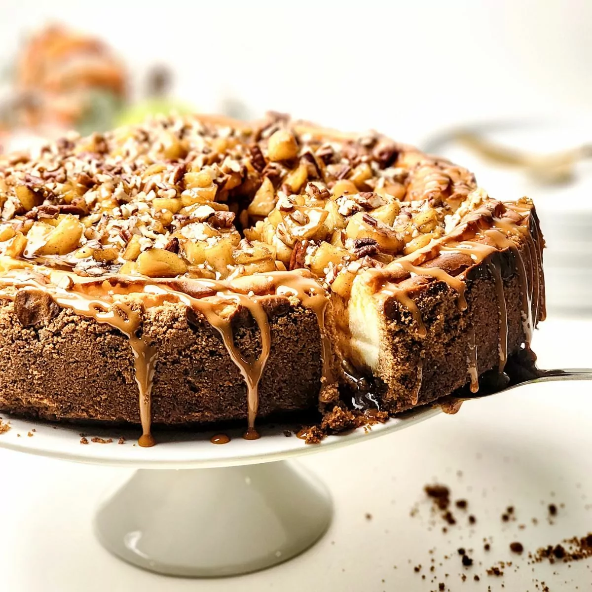 closeup of cheesecake on white cake stand.