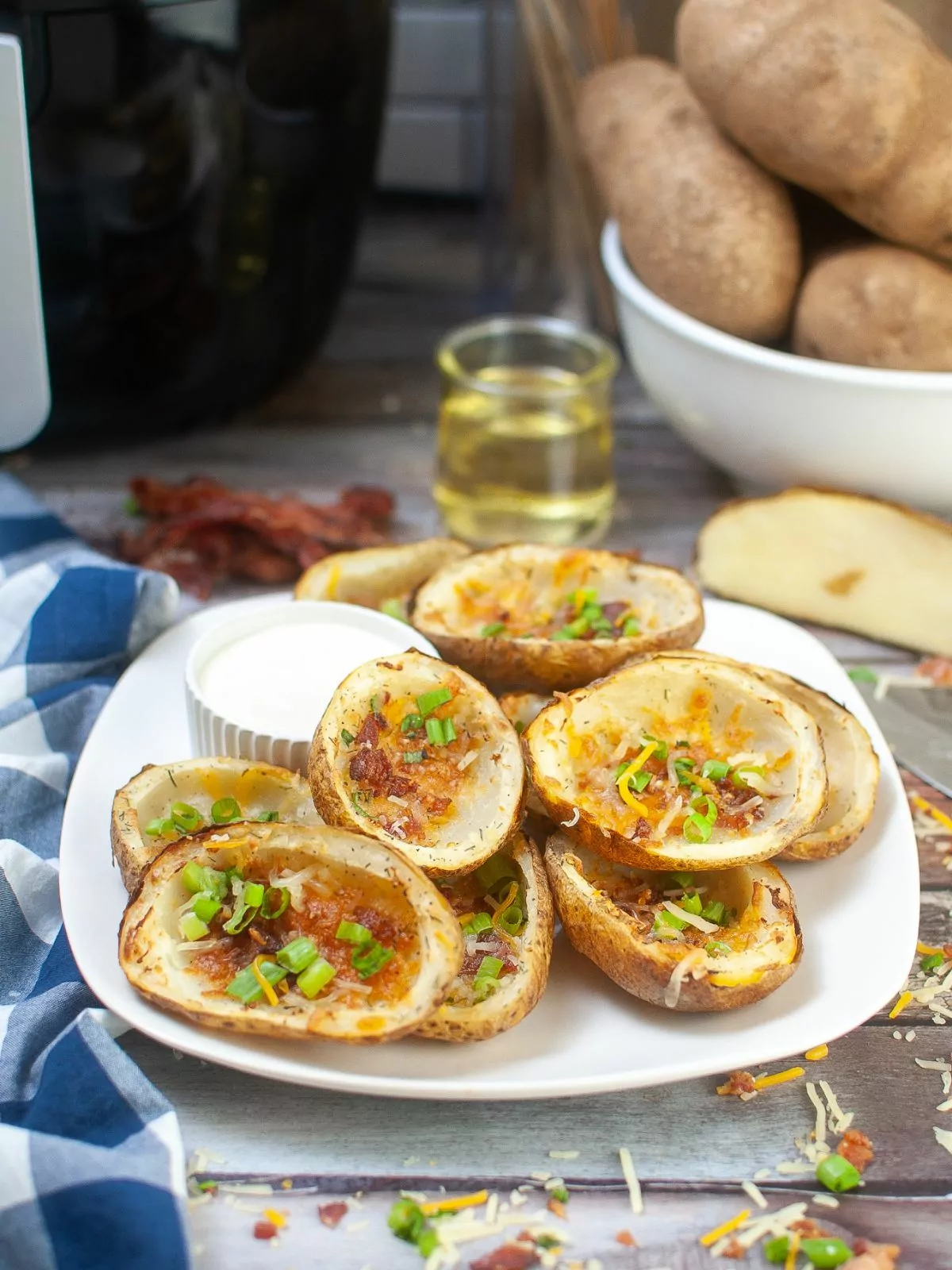 Air Fryer Potato Skins with an air fryer and bowl of russet potatoes in the background