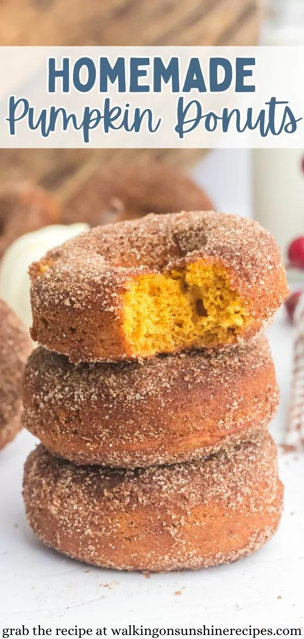 stack of 3 pumpkin donuts with the top one with a bite taken out showing the orange inside with text