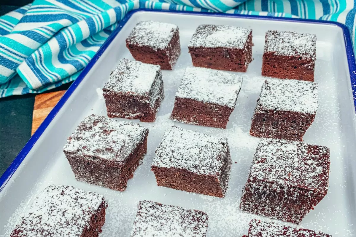 brownies on white tray with powdered sugar.