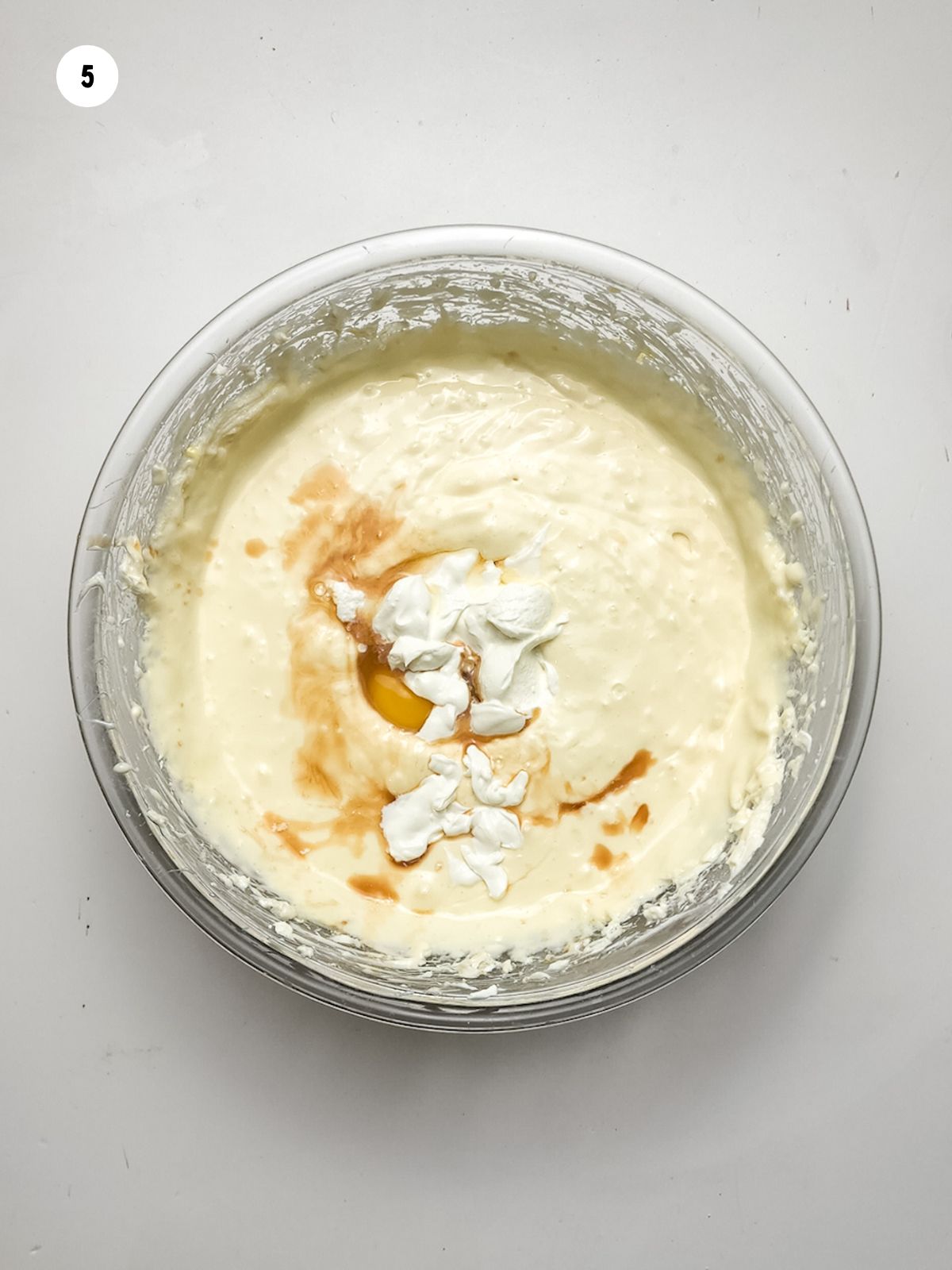 cheesecake mixture with sour cream and vanilla extract in bowl.