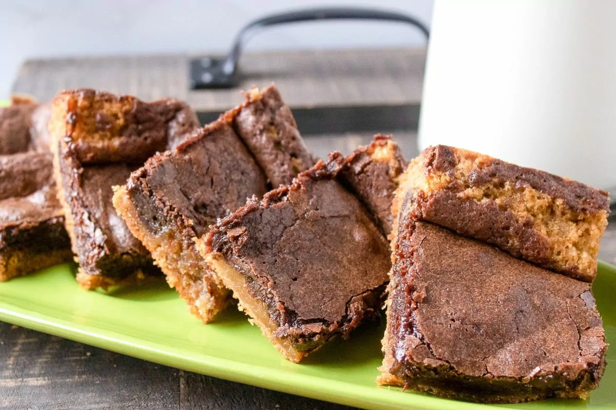 a plate of brownies with a glass of milk.