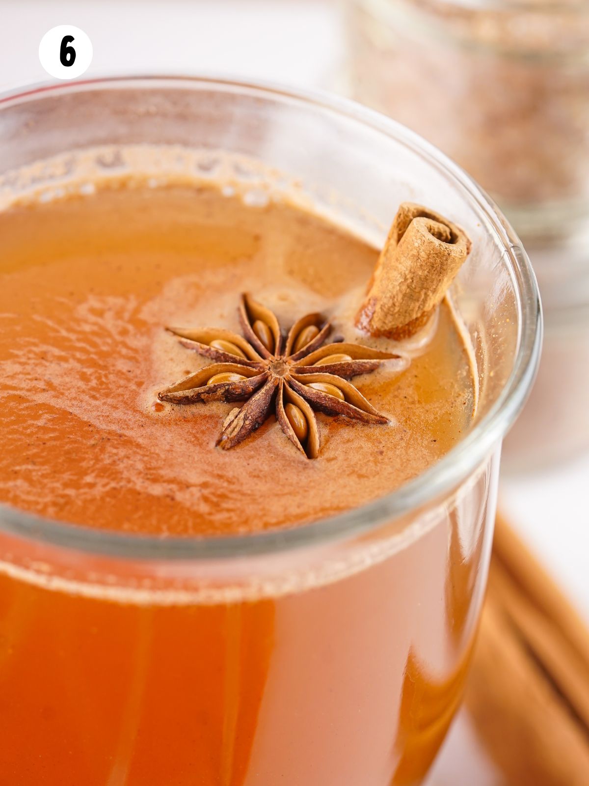 closeup of apple cider with cinnamon stick and star anise.