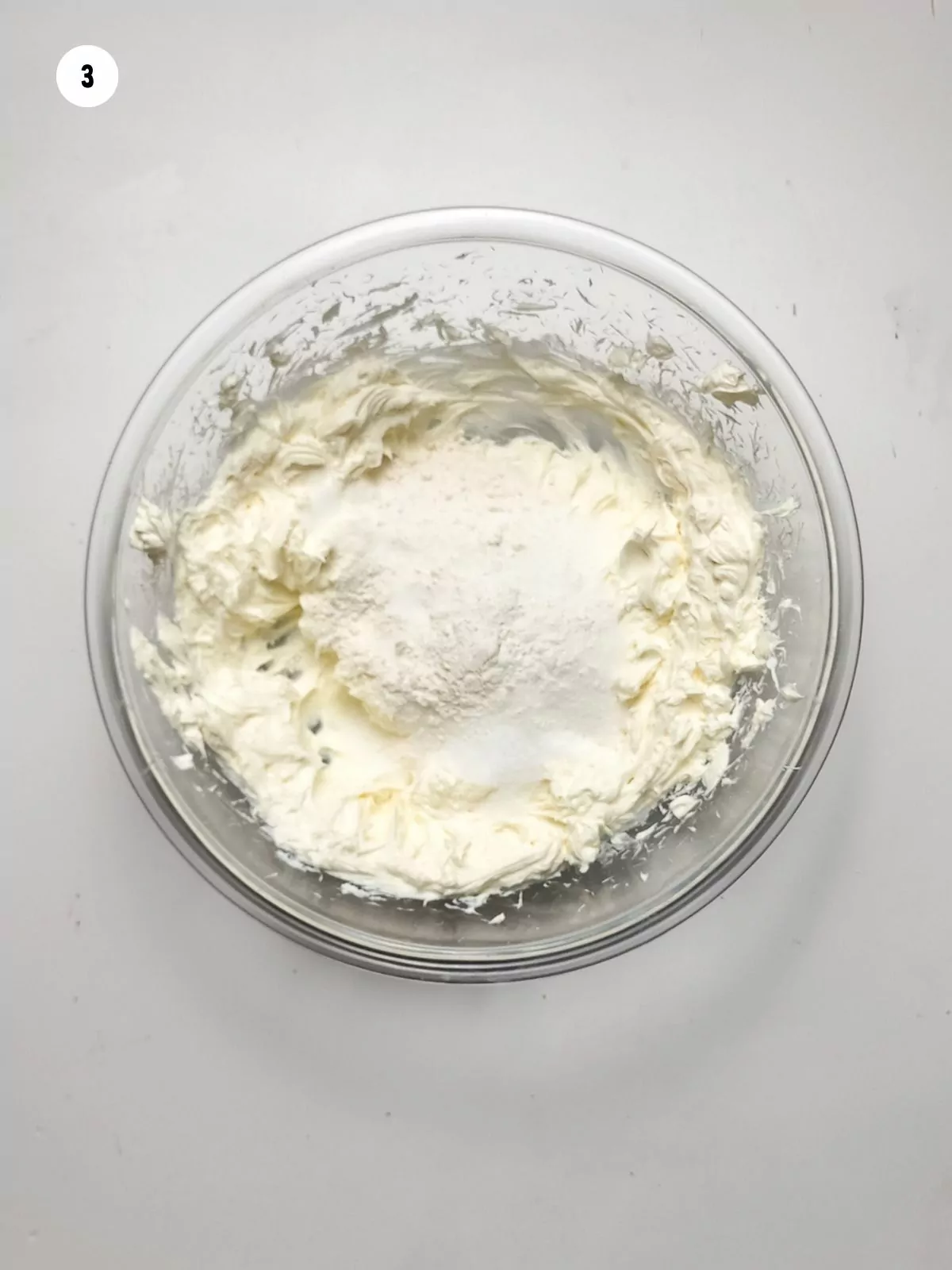 cream cheese with sugar in bowl before mixing.