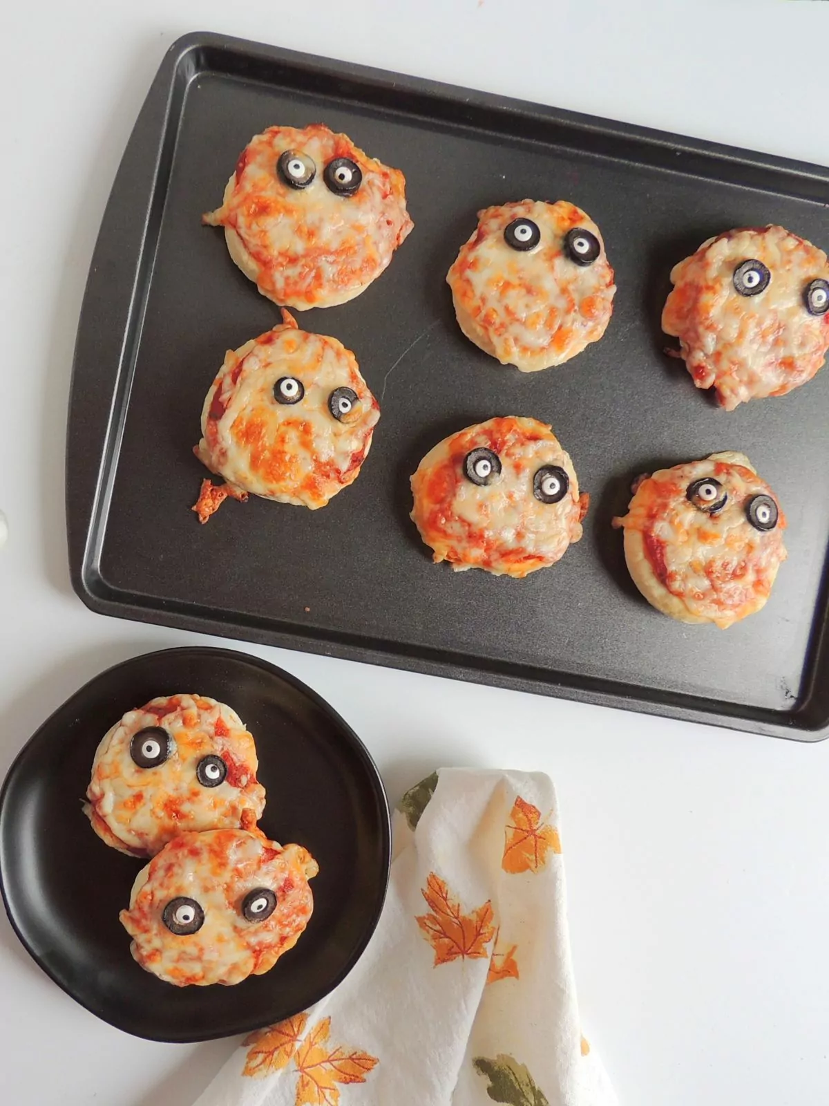 mummy pizza circles baked on plate and tray.