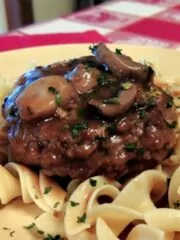 closeup photo of hamburger with gravy, mushrooms and buttered noodles.