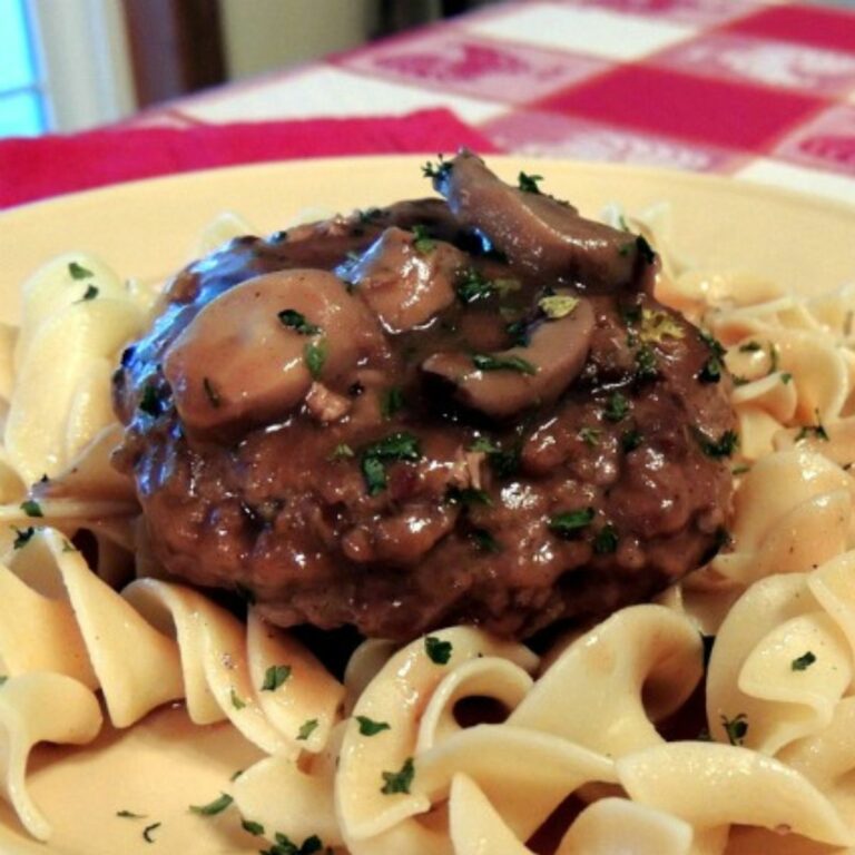 closeup photo of hamburger with gravy, mushrooms and buttered noodles.