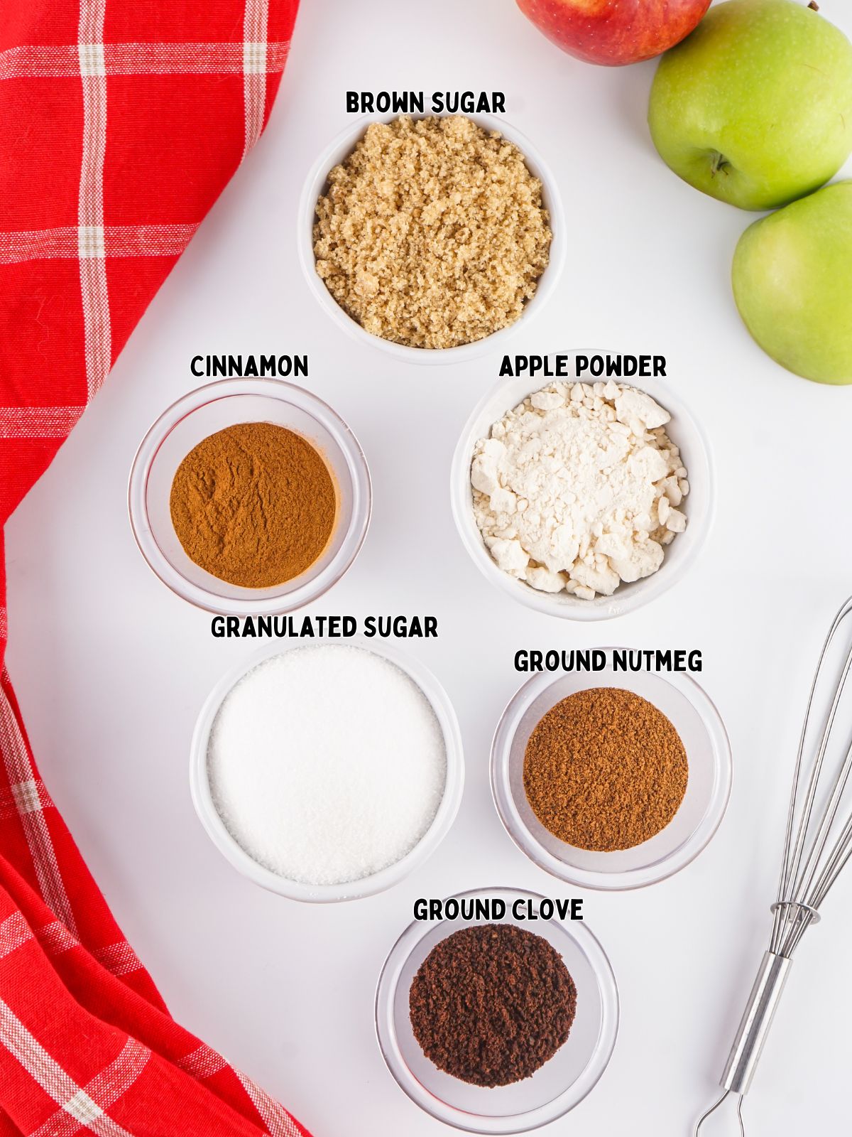 ingredients in small bowls of ground cloves, cinnamon, nutmeg, sugar, brown sugar and apple powder.