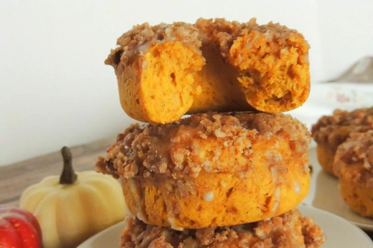 pumpkin donuts stacked on plate.