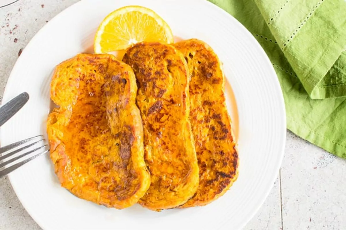 pumpkin orange french toast on white plate with green napkin.