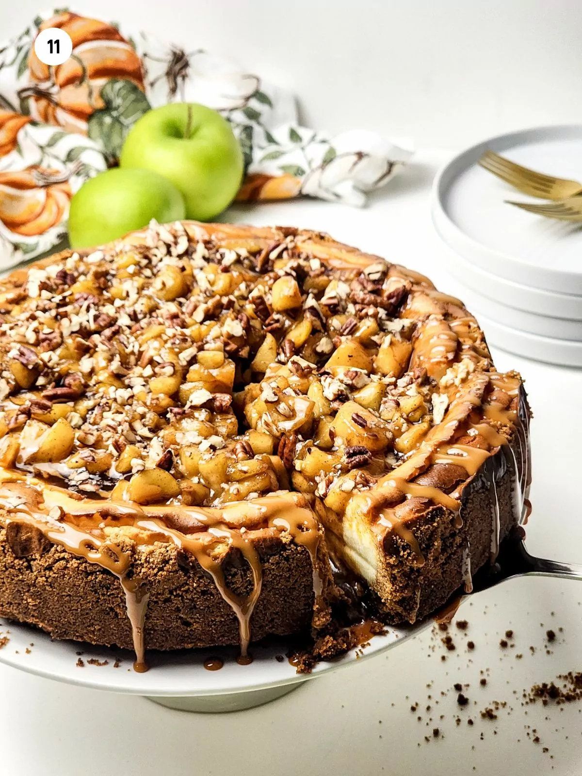 serving a slice of cheesecake with apples and caramel.