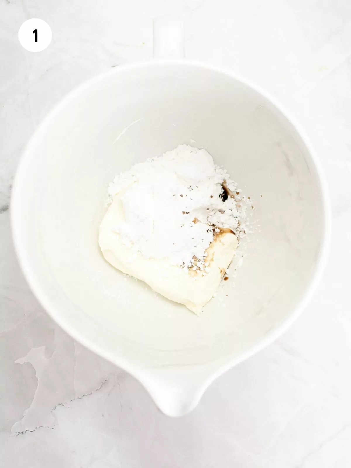 Mixing bowl filled with cream cheese, powdered sugar, and vanilla