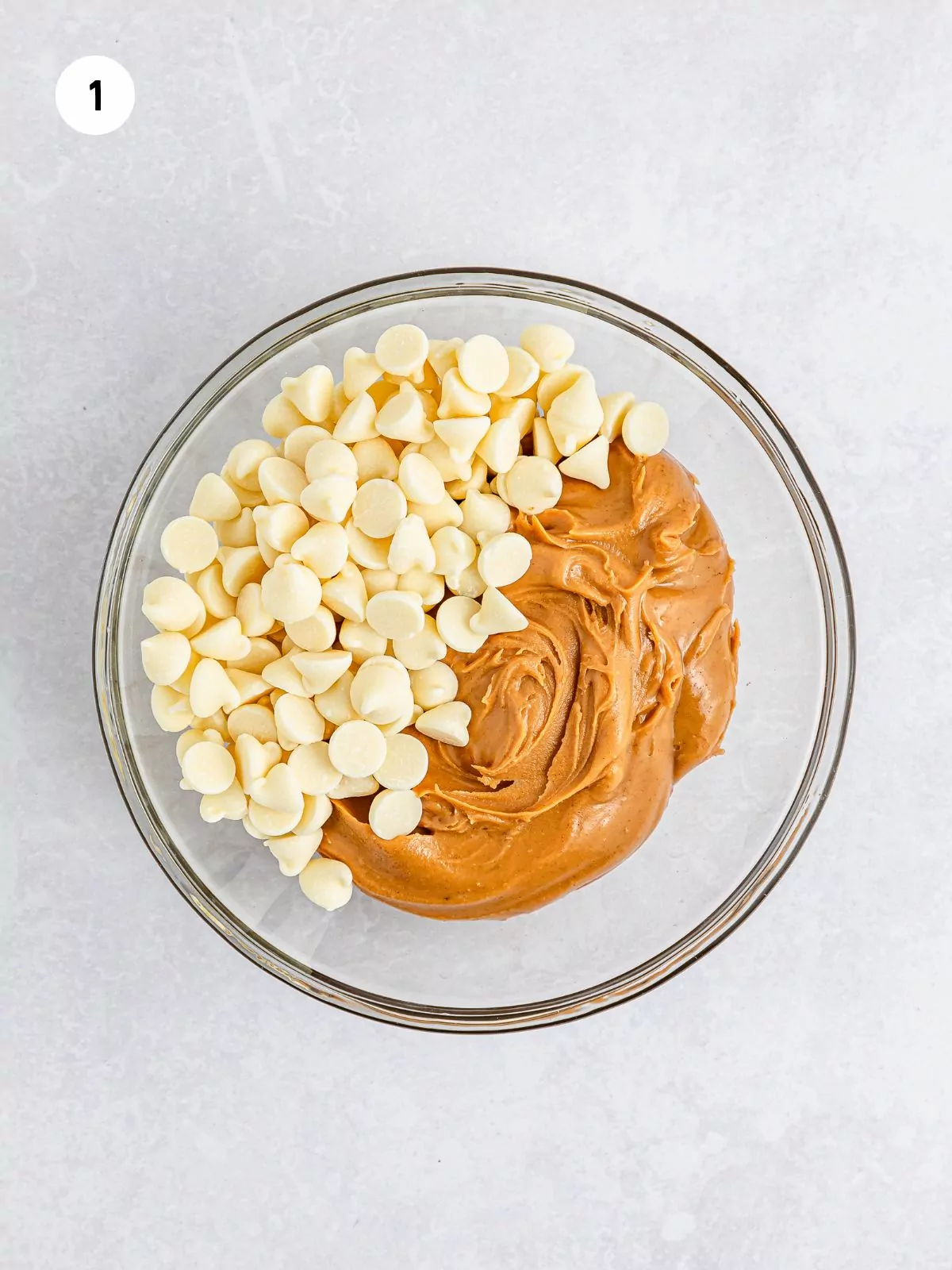 White chocolate chips and peanut butter in a clear bowl