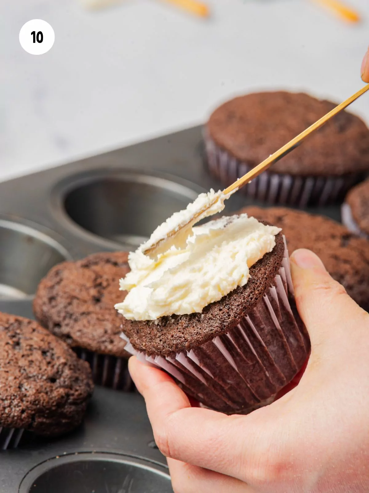 spatula frosting a cupcake