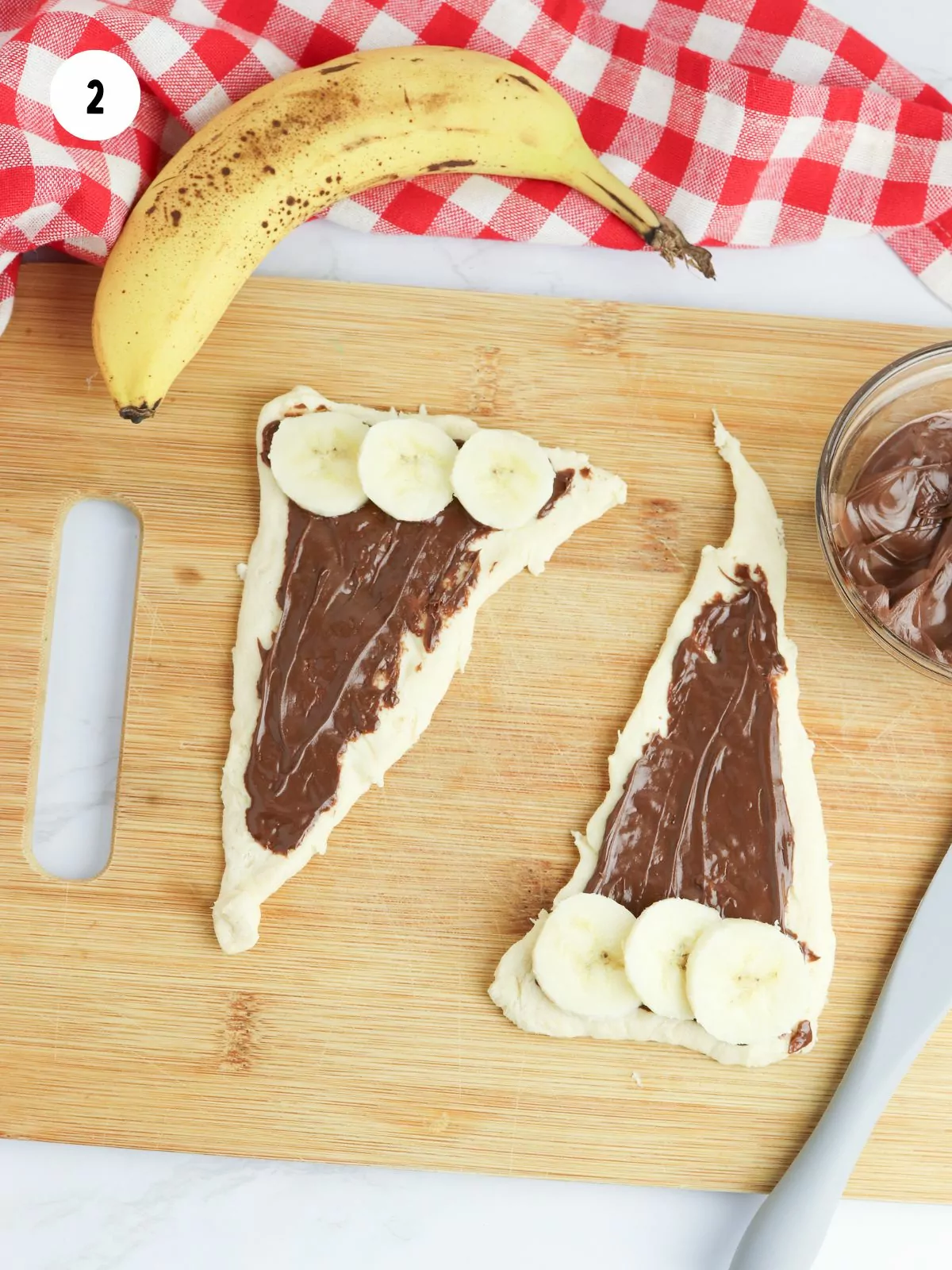 banana slices added to the wide end of the cresent roll with nutella