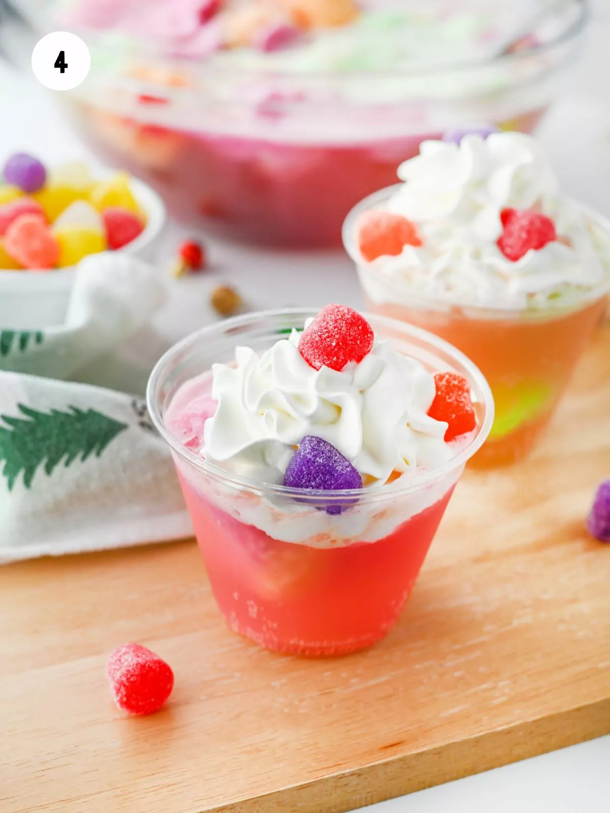 cup of punch with whipped topping and gumdrops on top