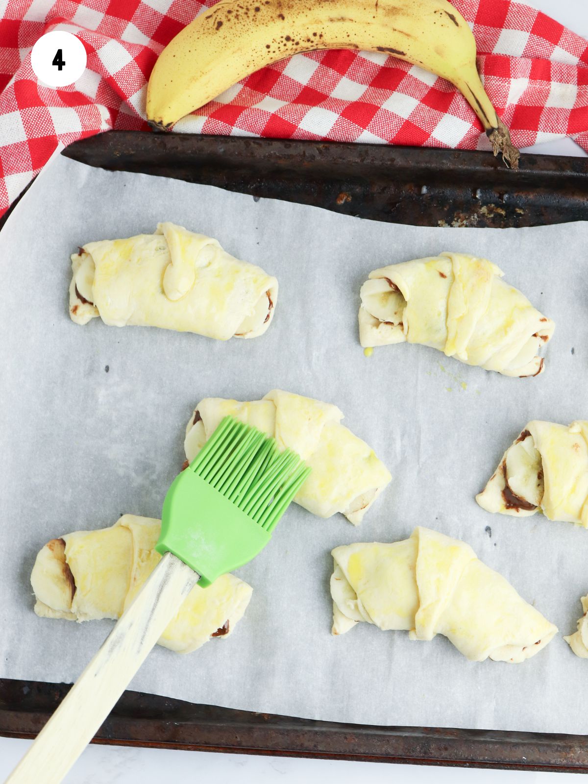 pastry brush adding egg wash to the crescent rolls