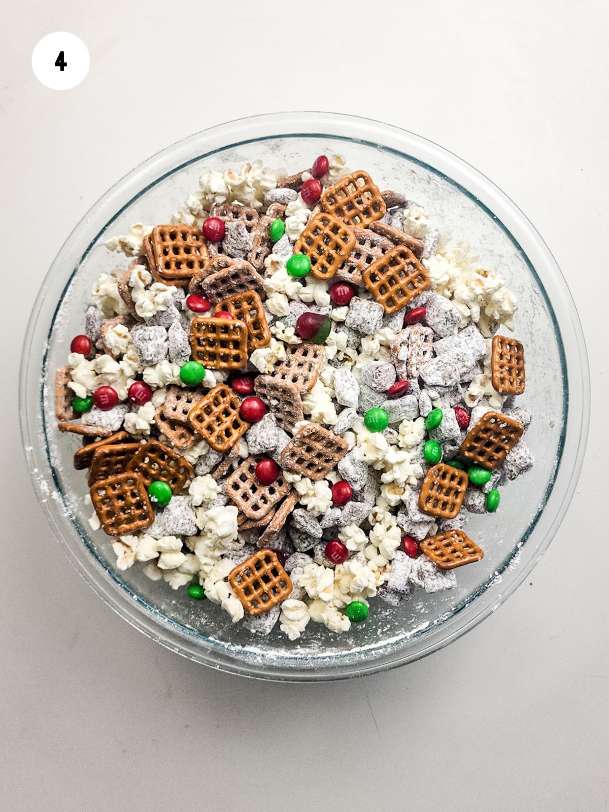 square pretzels and red and green candies added to the chex mix