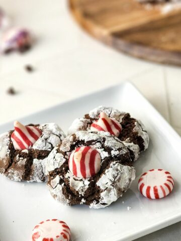 3 peppermint kiss cookies on white plate.