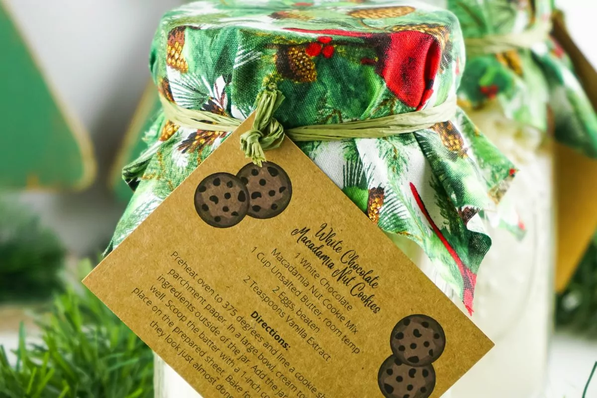 white chocolate macadamia cookies in mason jar with gift tag.