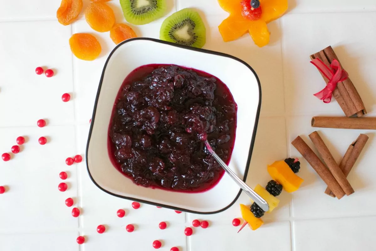 white bowl with spoon of cranberry sauce.