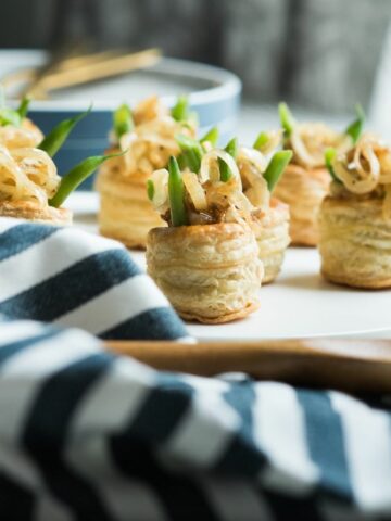 green beans in puff pastry rounds on serving tray.