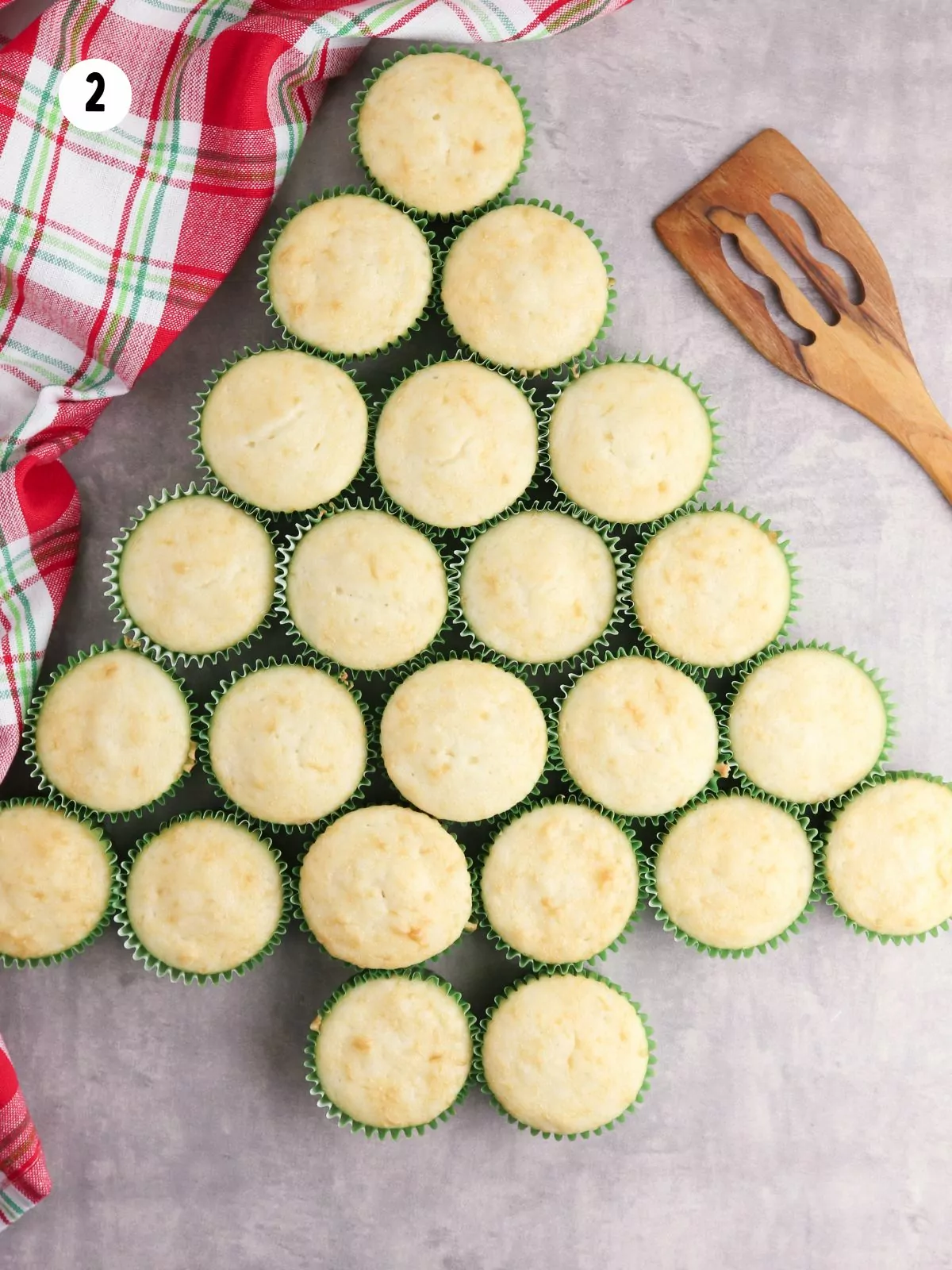 Cupcakes arranged in the shape of a Christmas tree without frosting.