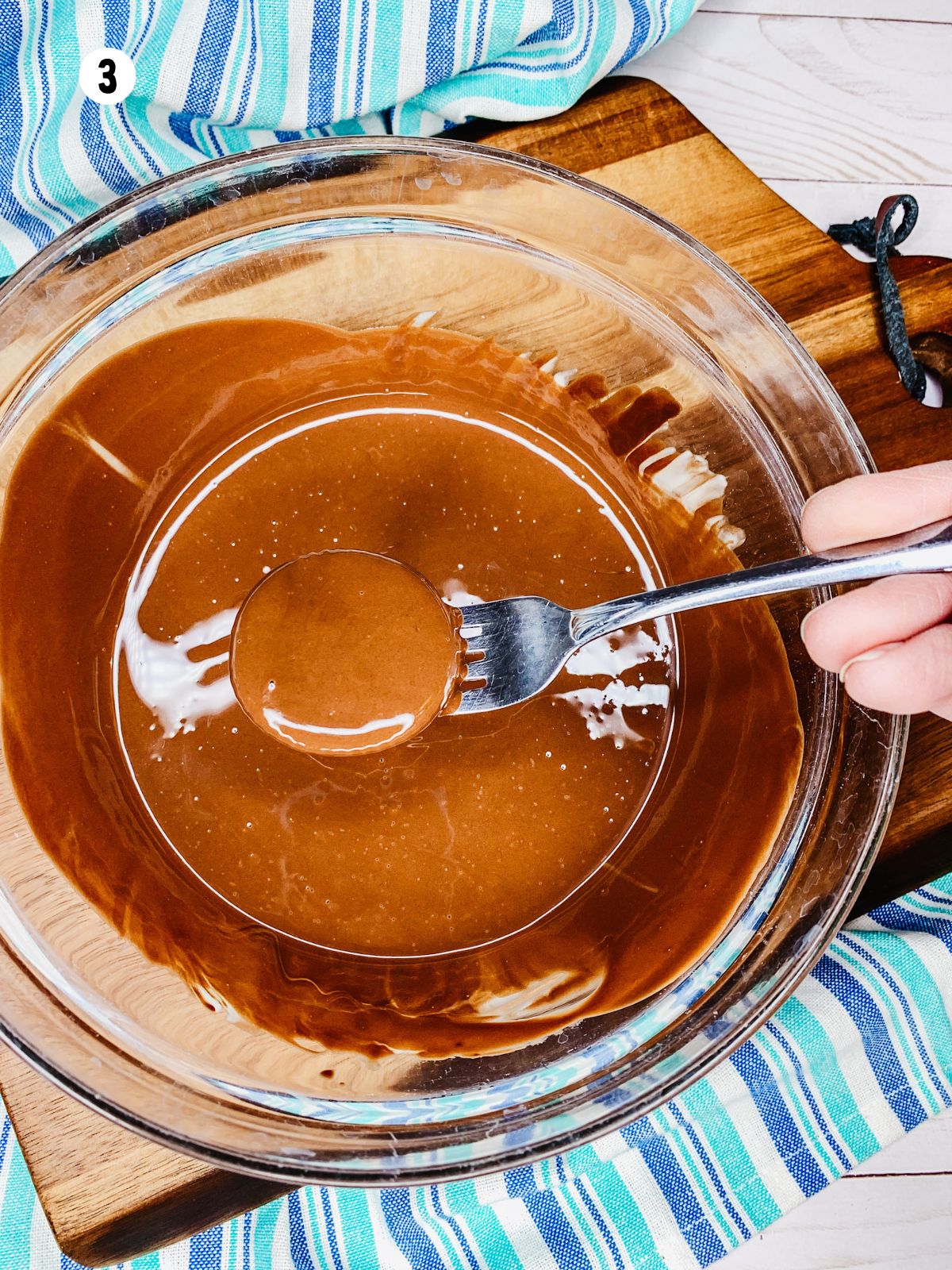 Ritz cracker dipped in melted chocolate on fork.