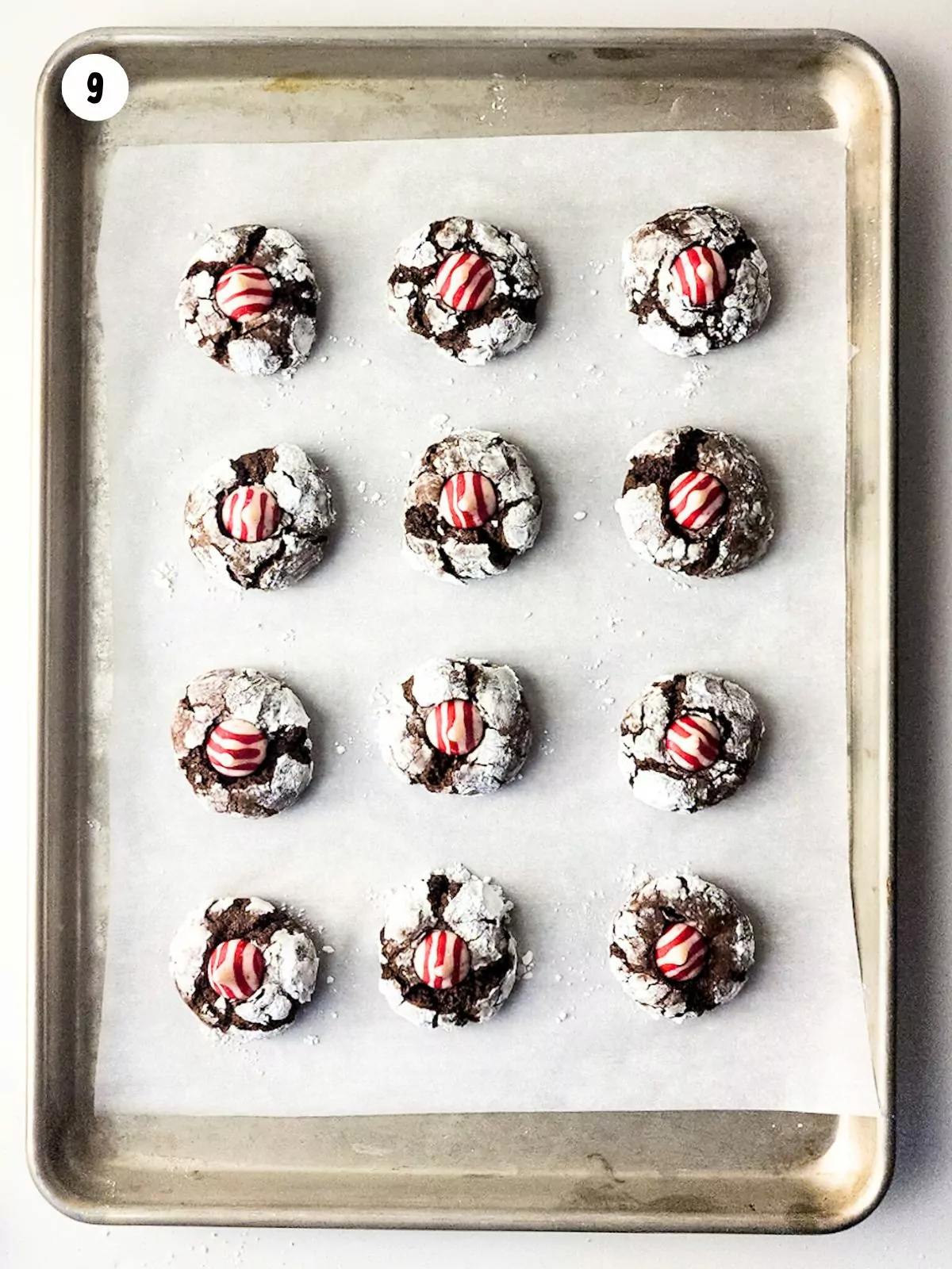 chocolate thumbprints with peppermint candies on baking tray.