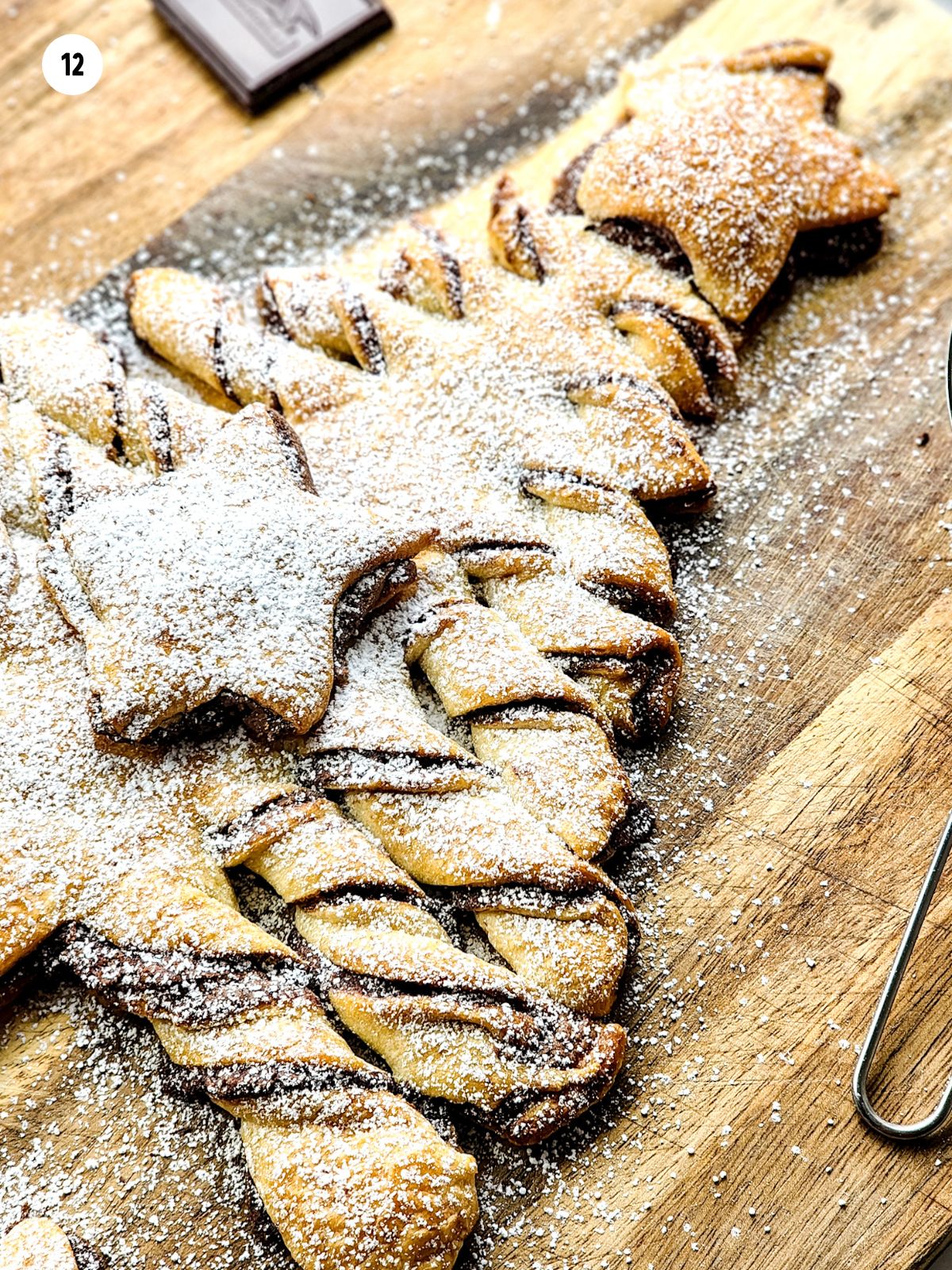 Christmas tree on cutting board with powdered sugar.