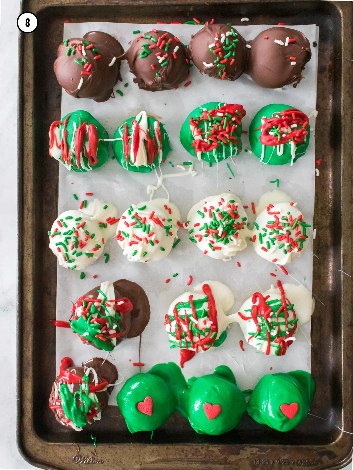 freshly dipped cookie balls lined up on baking tray with parchment paper.