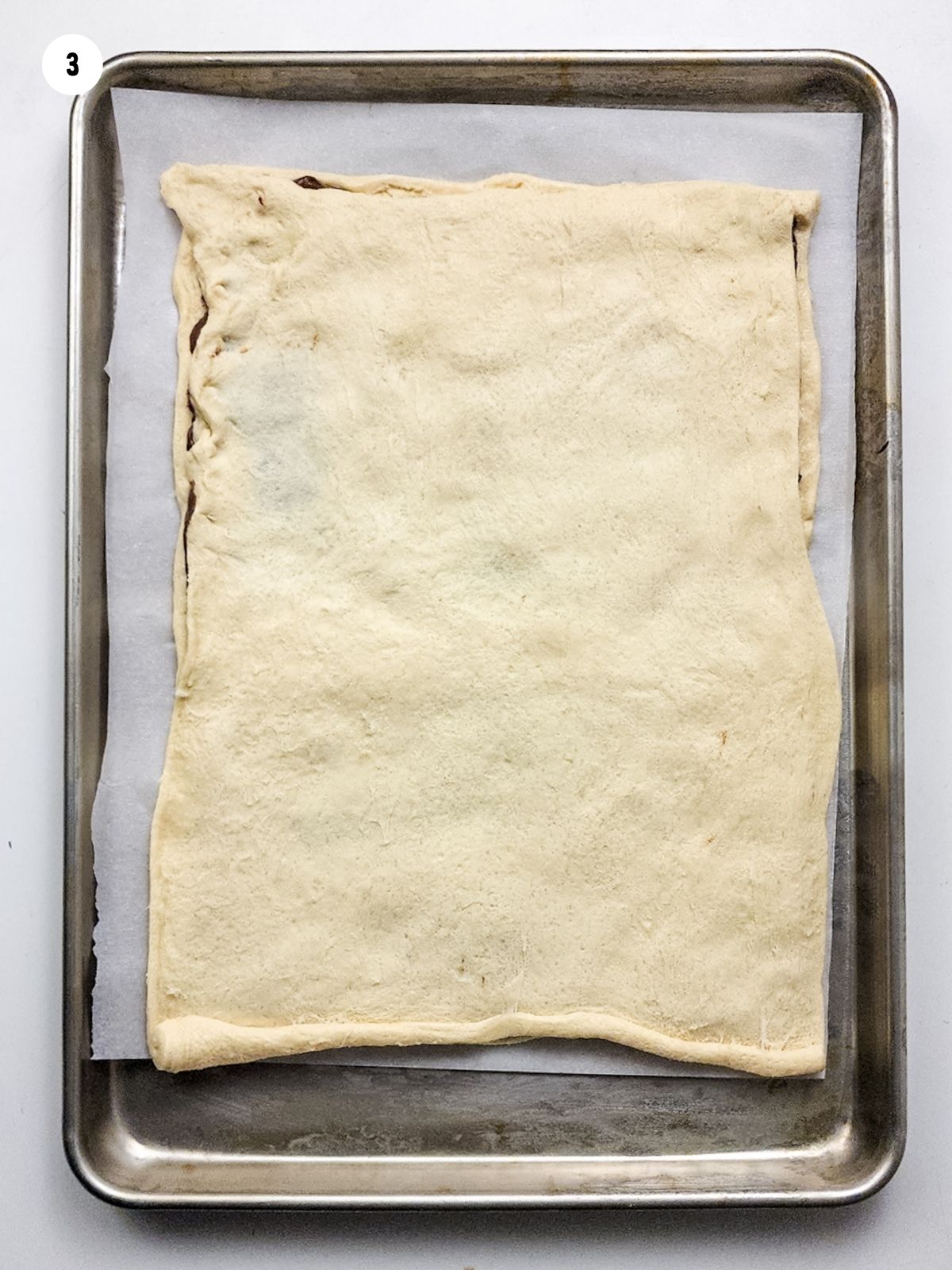 crescent roll sheet dough on baking tray.