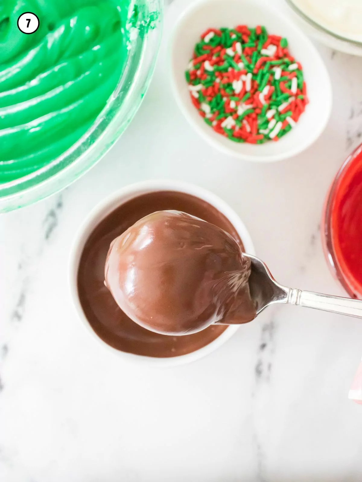 Dip Oreo cookie balls in melted chocolate with a fork.