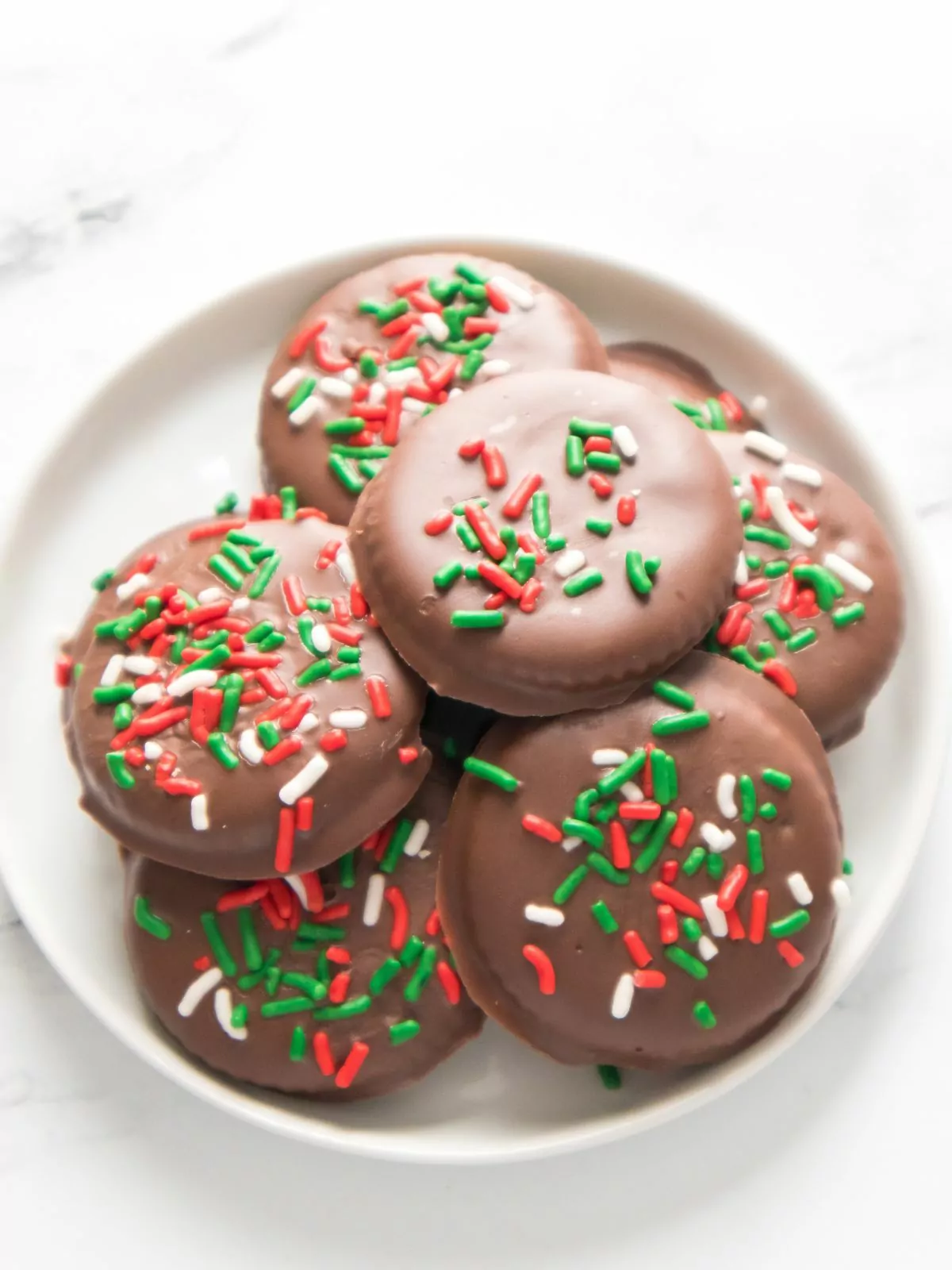 chocolate dipped cookies with sprinkles on plate.