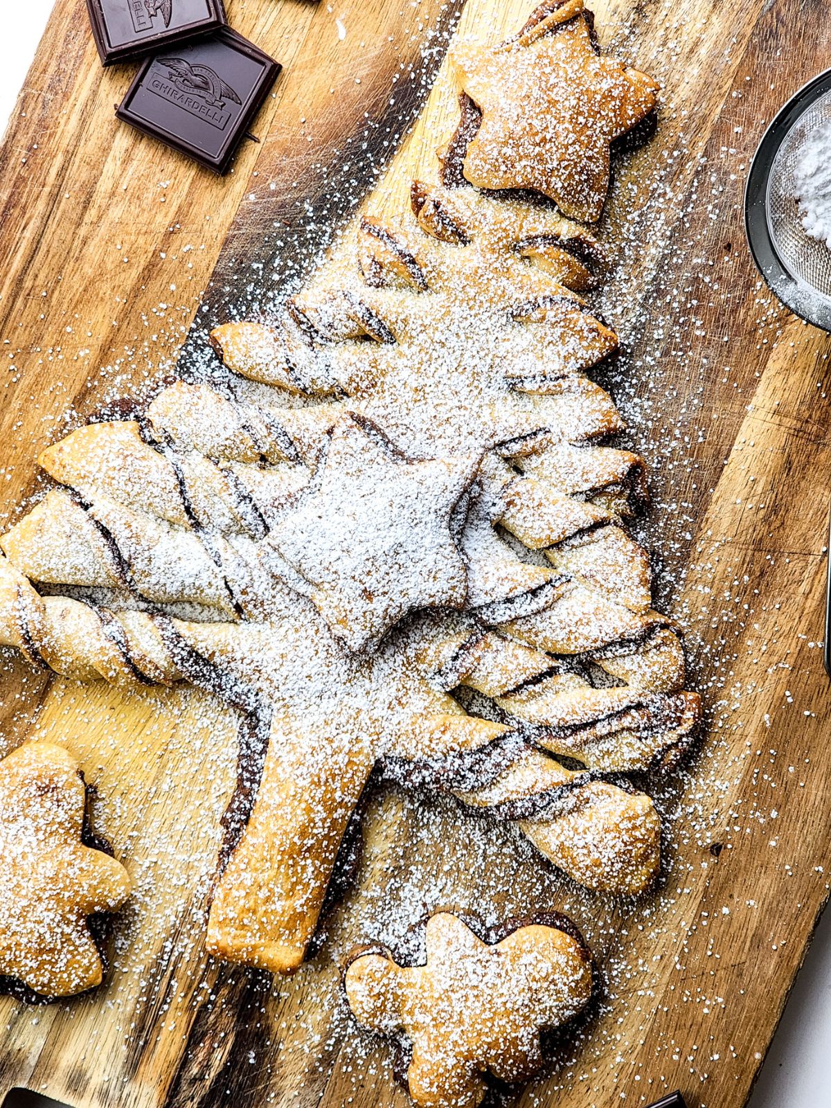 Christmas tree on cutting board baked with powdered sugar.