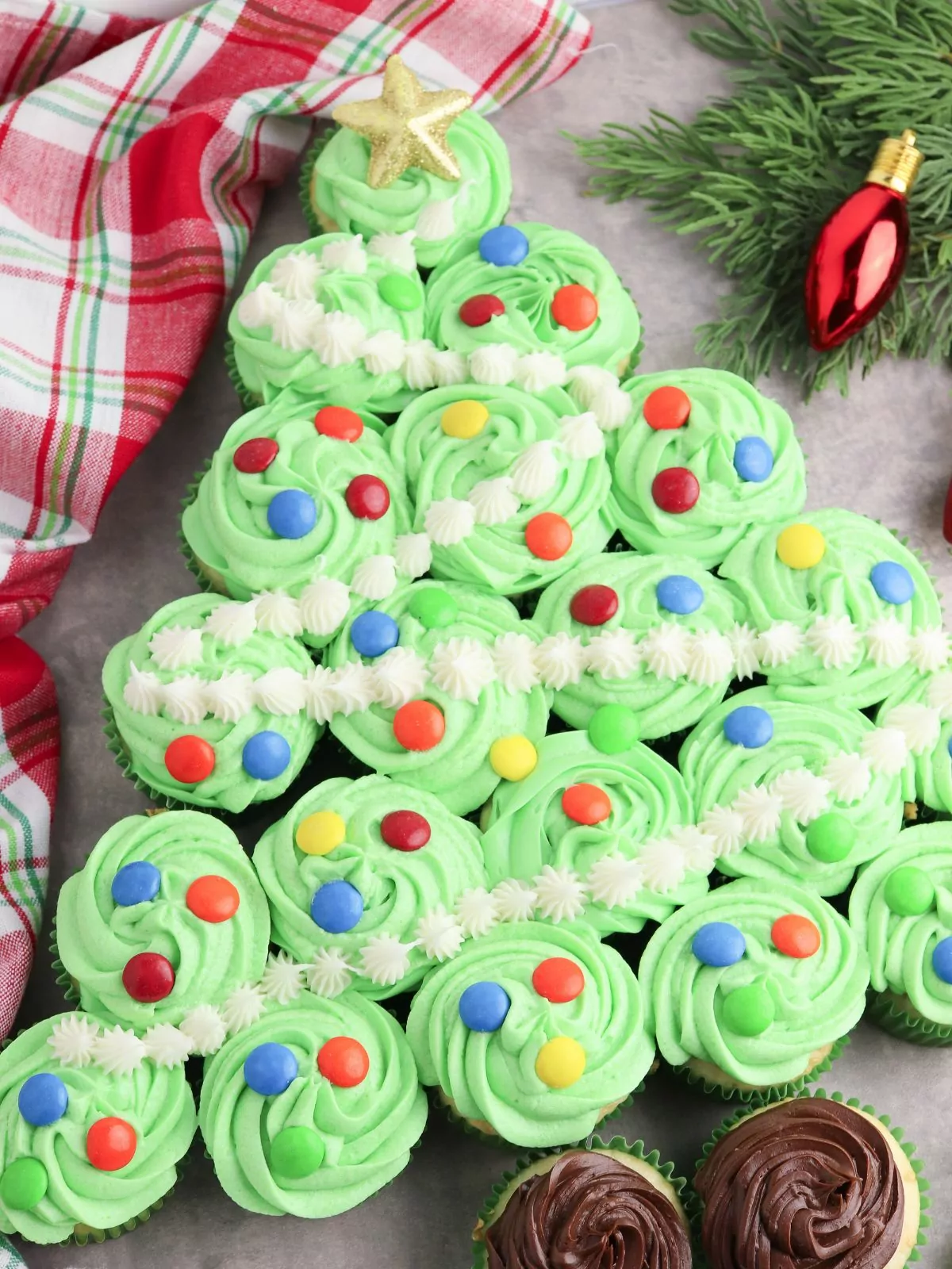 cupcakes arranged in the shape of a christmas tree decorated with candy pieces.