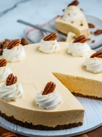 pumpkin cheesecake on round wooden board.