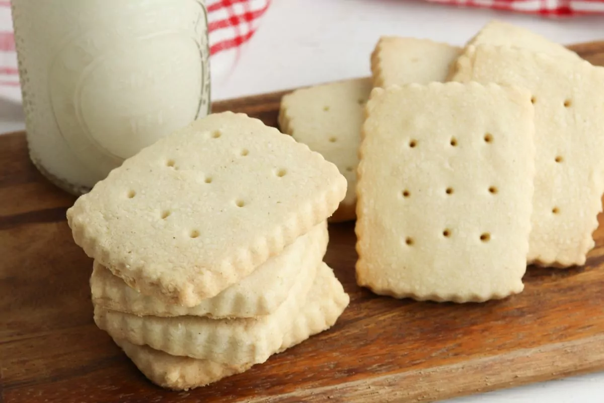 stack of shortbread cookies with glass of milk in the background.