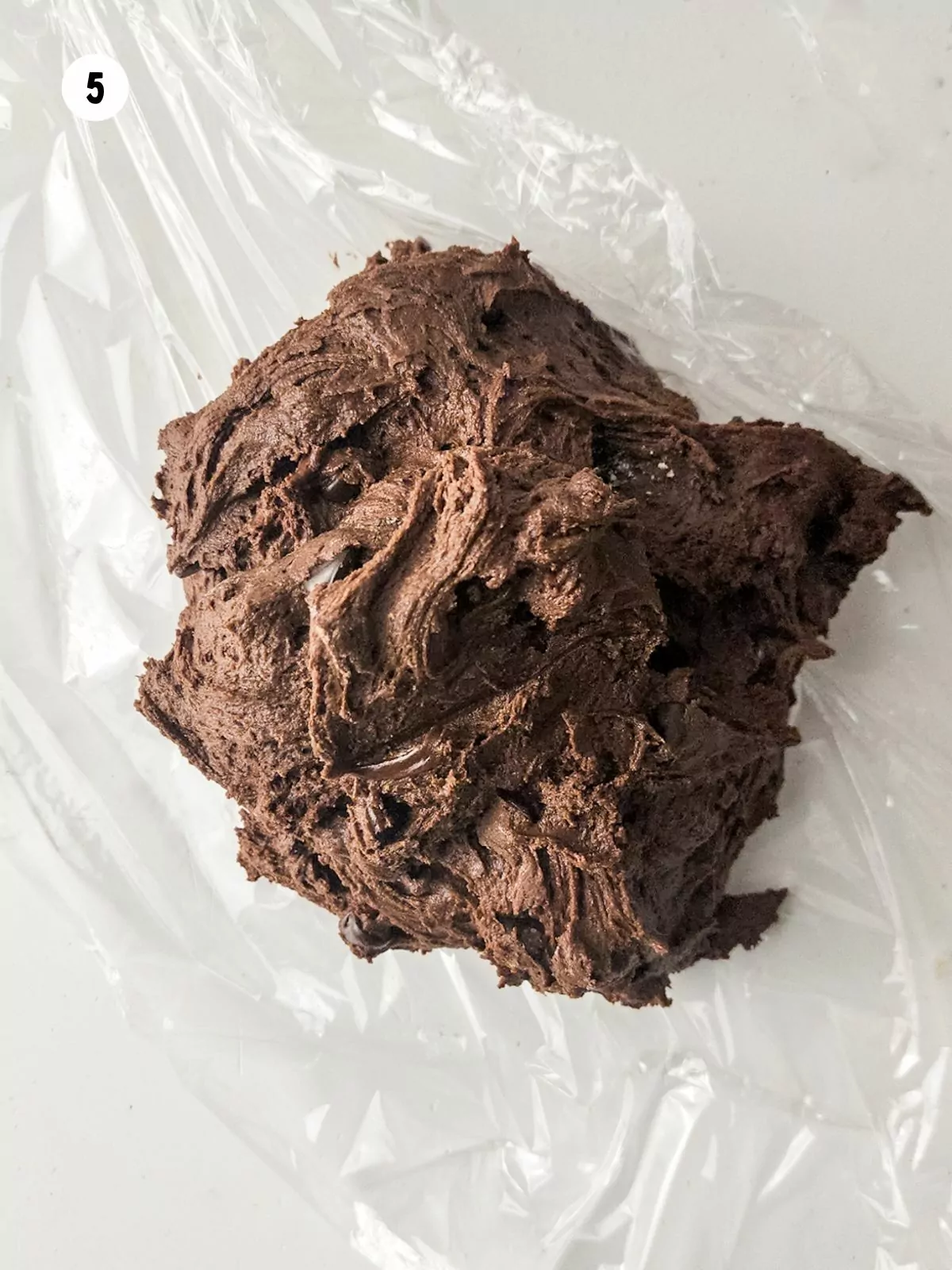 chocolate cookie dough on top of plastic wrap.